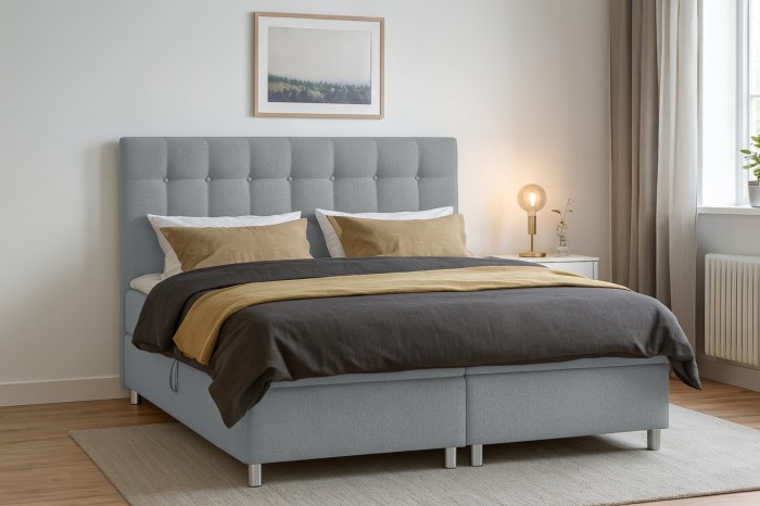 Modernes graues Boxspringbett mit gestepptem Kopfteil im minimalistischen Schlafzimmer.