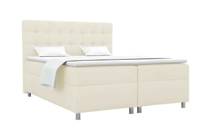 Beiges Boxspringbett mit gestepptem Kopfteil, Matratze und Topper auf silbernen Füßen.