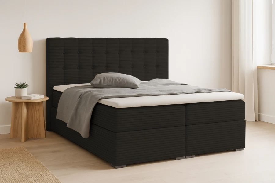 Elegantes Boxspringbett in Schwarz mit Cord-Bezug und gestepptem Kopfteil in modernem Schlafzimmerambiente.