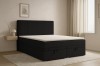 DAGA Boxspringbett in Schwarz in einem stilvoll eingerichteten, hellen Schlafzimmer.