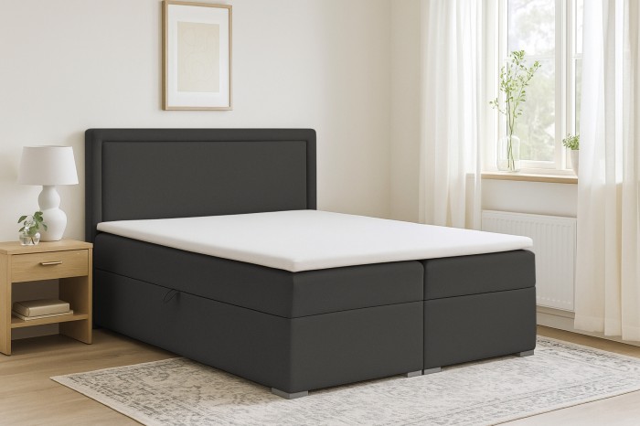 Modernes Boxspringbett Dream in Dunkelgrau mit weißem Topper in hellem Schlafzimmer.