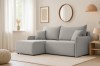 Hellgraues Ecksofa in L-Form in einem modern eingerichteten Wohnzimmer mit heller Dekoration.