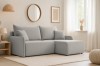 Gemütliches hellgraues Ecksofa im minimalistischen Wohnzimmer mit Ottoman auf der rechten Seite.