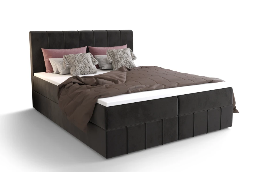 Dunkelgraues Boxspringbett mit Kissen und Decke freigestellt auf Weiß.