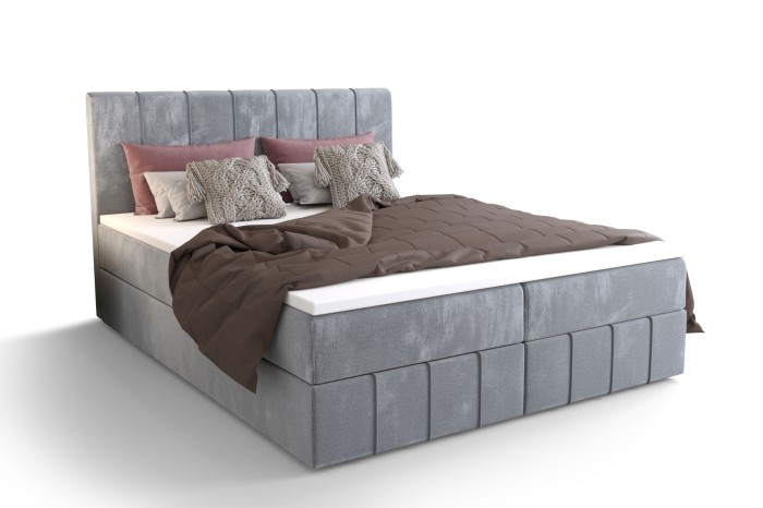 Hellgraues Boxspringbett mit braunem Plaid auf weißem Hintergrund freigestellt.