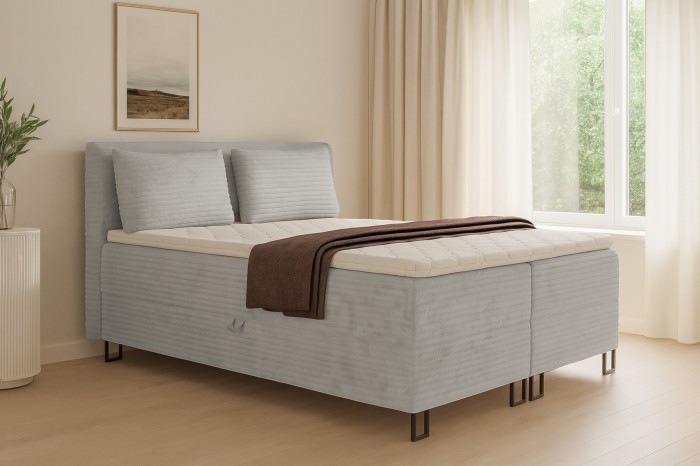 Boxspringbett Texas in Grau in einem hellen, modernen Schlafzimmer-Ambiente.