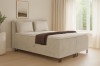 Modernes Boxspringbett Texas in Beige im hellen Schlafzimmer für erholsamen Schlaf.