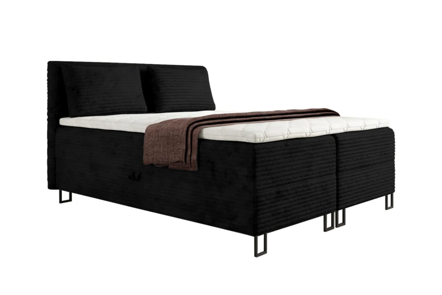 Modernes schwarzes Boxspringbett aus Cord mit weißem Topper und brauner Decke.