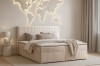 Schlafzimmer-Inspiration mit beigem Cord-Boxspringbett und beleuchteter Weltkarte an der Wand.