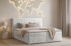Gemütliches Boxspringbett im Cord-Design in einem hellen Schlafzimmer mit moderner Wanddekoration.