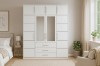 Large white wardrobe with mirror doors and top cupboard in a bright bedroom.