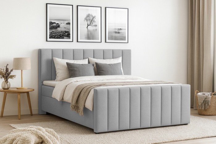 Gemütliches Schlafzimmer mit hellgrauem Boxspringbett FEN, Dekokissen und Wandbildern.