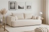 Beiges Bouclé-Sofa in hellem Wohnzimmer mit moderner Dekoration und Teppich.