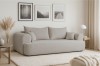 Modernes beiges Sofa in einem minimalistisch eingerichteten Wohnzimmer mit Wandbildern.