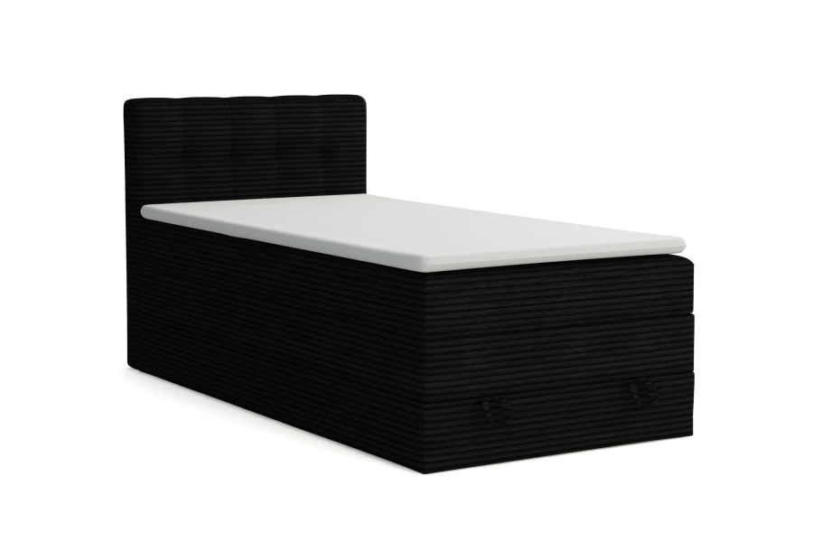 Schwarzes Boxspringbett aus Cord mit weißem Topper auf weißem Hintergrund.