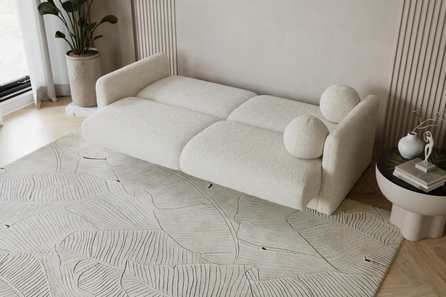 Perspektivische Ansicht eines beigen Bouclé-Sofas auf einem gemusterten Teppich.