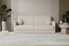 Frontalansicht eines Zweisitzer-Sofas in Beige Bouclé-Optik vor einer Lamellenwand.