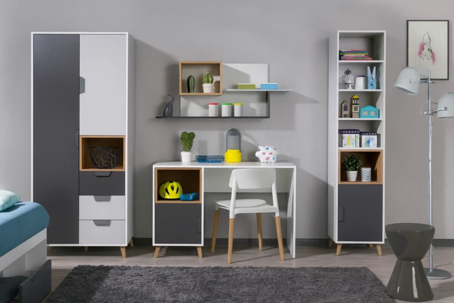 Children's desk set with cupboard and shelf in grey-white in front of a grey wall.