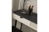 Nahaufnahme eines eleganten Konsolentisches mit Marmoroptik und Make-up-Pinseln.