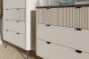 Detail von beigen Kommoden mit moderner Riffeloptik und schwarzen Griffen.