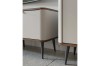 Nahaufnahme moderner Möbelbeine an einem cremefarbenen Sideboard mit elegantem dunklem Holzrahmen.