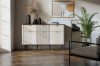 Modernes Sideboard in Creme mit Rillenstruktur und dunklen Akzenten im Wohnzimmer.
