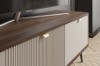 Detailansicht eines TV-Boards mit Nussbaumplatte, geriffelter Front und goldenen Griffen.