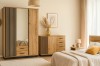 Brightly furnished bedroom with Lami furniture set: mirror wardrobe, chest of drawers and bed in warm wood look.