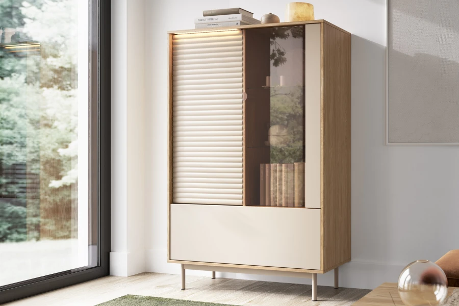 Nahaufnahme der TOGY Vitrine 01 mit Beleuchtung, dekoriert mit Büchern in einem hellen Wohnzimmer.