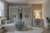 Modernes Schlafzimmer-Set in Beige mit großem Kleiderschrank, Sideboard und gemütlichem Bett mit grüner Decke.