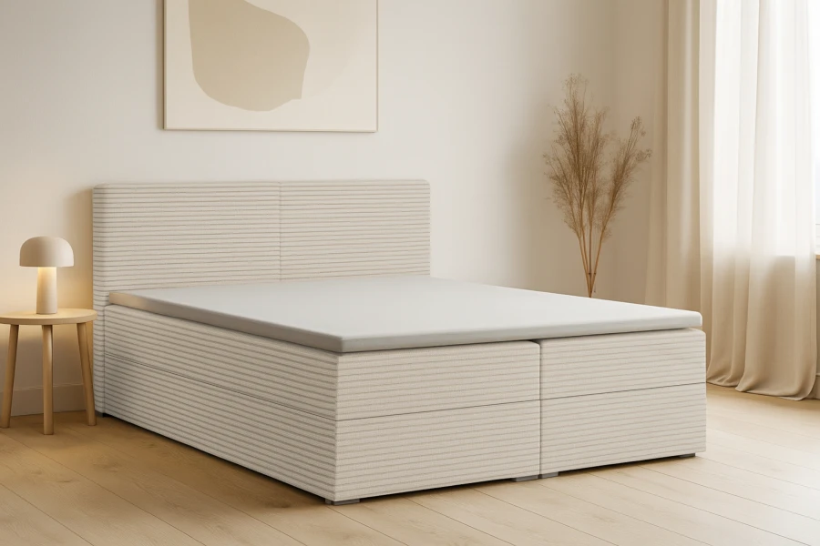 Stilvoll eingerichtetes Schlafzimmer mit einem modernen Boxspringbett aus beigem Cord-Stoff.