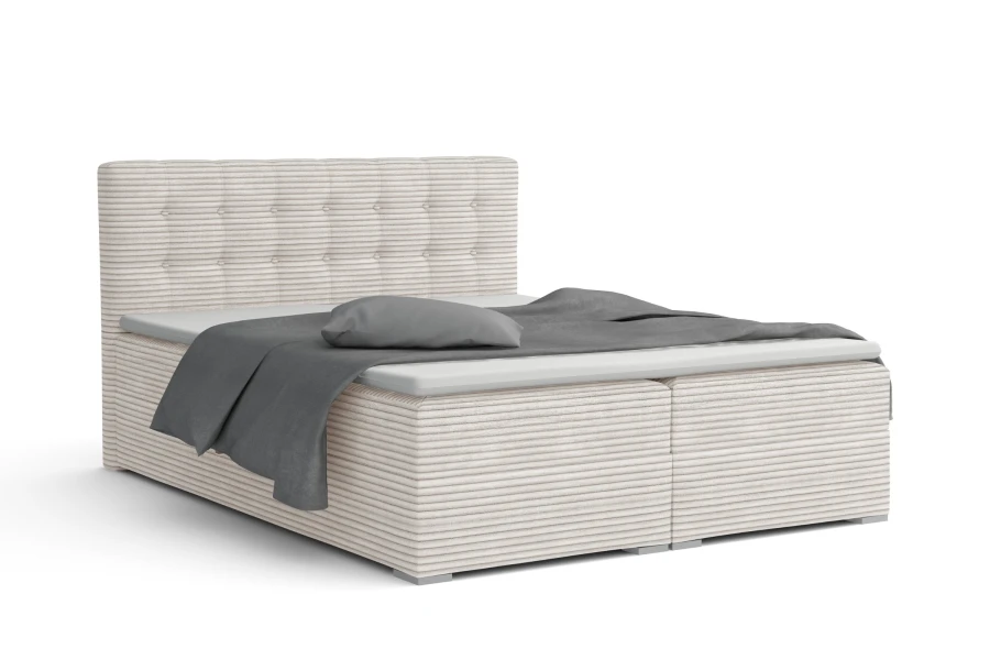 Beiges Boxspringbett aus Cord-Stoff mit gestepptem Kopfteil und grauer Bettwäsche auf weißem Grund.