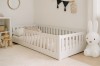 Weißes Juniorbett aus Holz mit Rausfallschutz für einen sicheren Schlaf im Kinderzimmer.