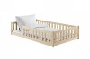 Niedriges Kinderbett aus hellem Kiefernholz mit weißer Bettwäsche und Kissen.