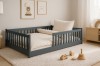 Gemütliches Kinderzimmer mit grauem Hausbett, flauschigem Teppich und Wandbildern