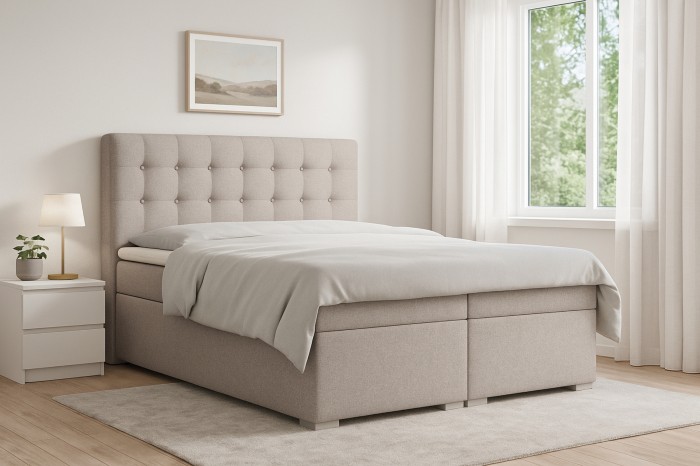Beiges Boxspringbett Claudia mit gestepptem Kopfteil im hellen Schlafzimmer.