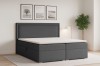 Modernes dunkelgraues Boxspringbett mit gestreiftem Kopfteil vor weißer Wand im Schlafzimmer.
