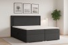 Anthrazitfarbenes Boxspringbett mit geriffeltem Kopfteil und weißem Topper im modernen Schlafzimmer.