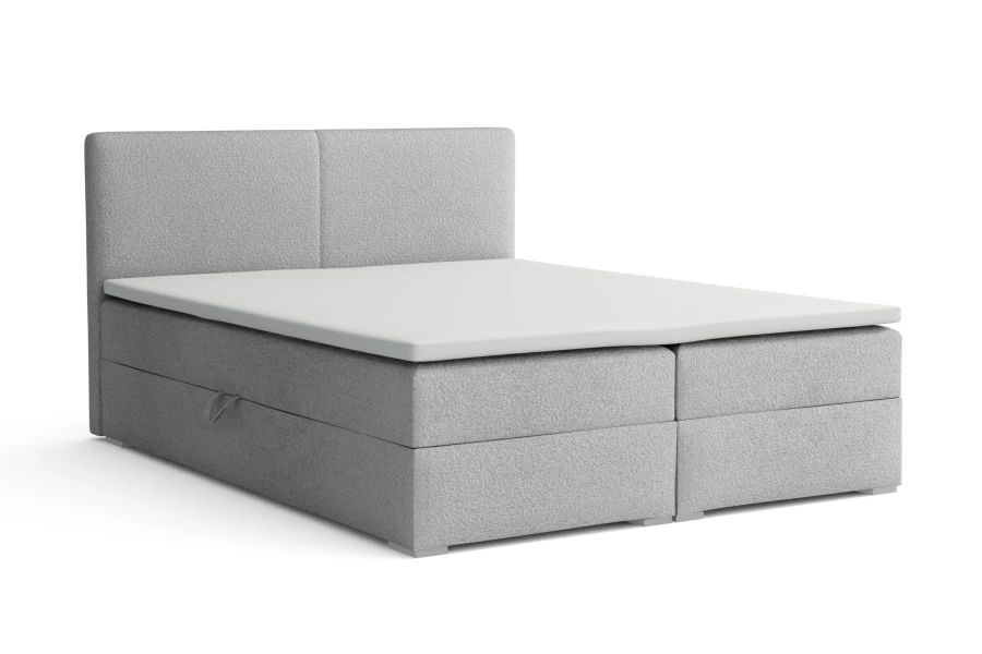 Moderne lichtgrijze boxspring met gestoffeerd hoofdbord en wit matras.