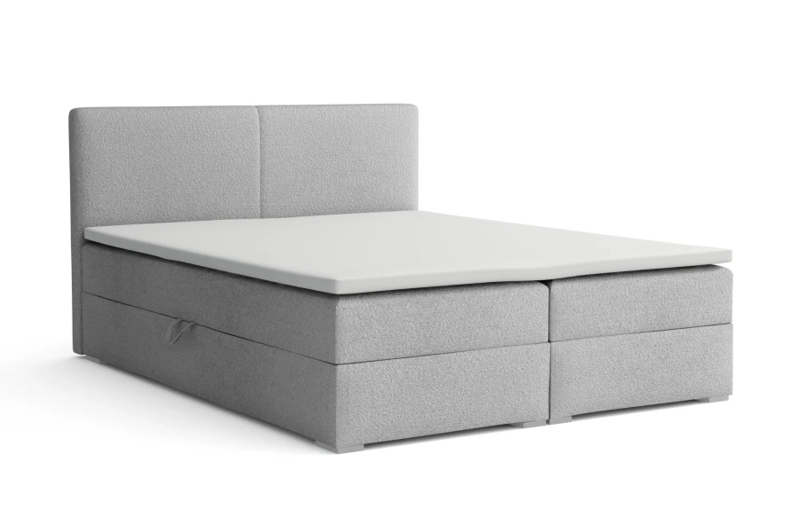 Modernes hellgraues Boxspringbett mit gepolstertem Kopfteil und weißer Matratze.
