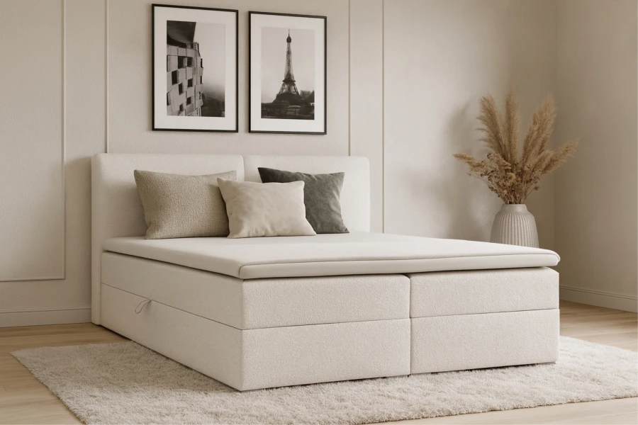 Stilvolles Schlafzimmer-Ambiente mit einem weißen Boxspringbett und Wandkunst.