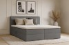 Graues Boxspringbett in modernem Schlafzimmer mit dekorativen Kissen.