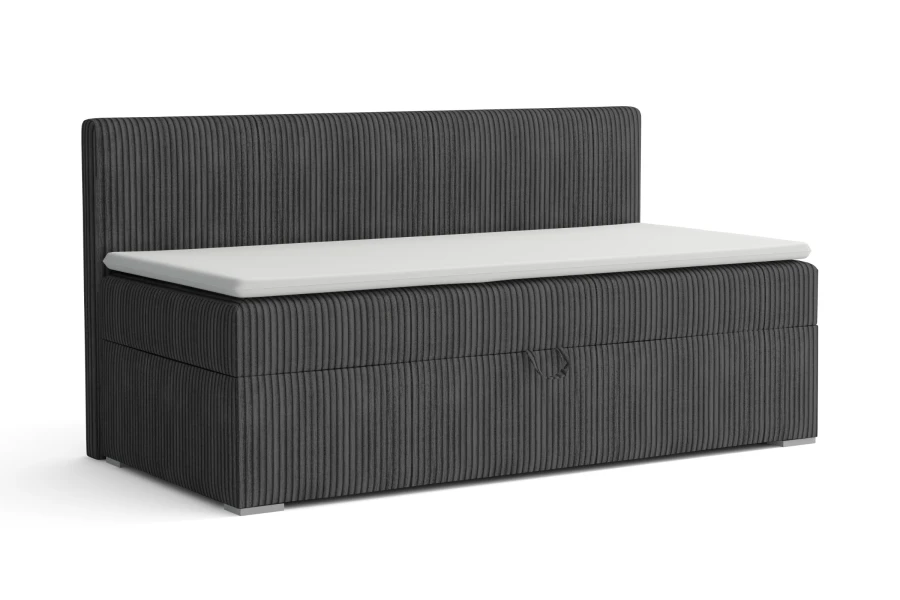 Grijze gestoffeerde bank met cord-bekleding en wit zitkussen.