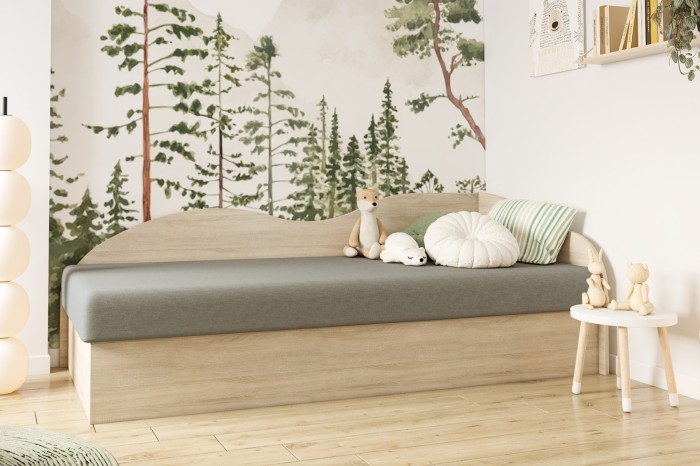 Kinderbett aus Holz mit Wald-Motivtapete und Kuscheltieren im hellen Kinderzimmer.