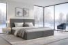 Anthrazitfarbenes Doppelbett in hellem Schlafzimmer mit großen Fenstern und Blick auf Winterlandschaft.