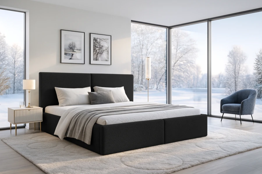 Modernes schwarzes Polsterbett im hellen Schlafzimmer mit winterlichem Ausblick durch große Fenster.