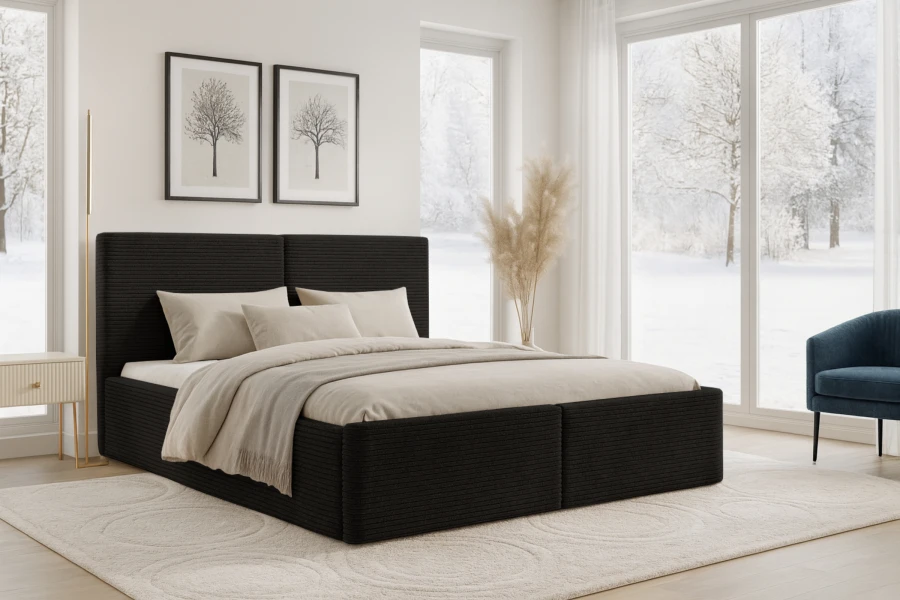 Gemütliches Schlafzimmer mit schwarzem Polsterbett Ben und Blick auf eine Winterlandschaft.