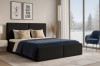 Elegantes schwarzes Boxspringbett im modernen Schlafzimmer mit Aussicht.