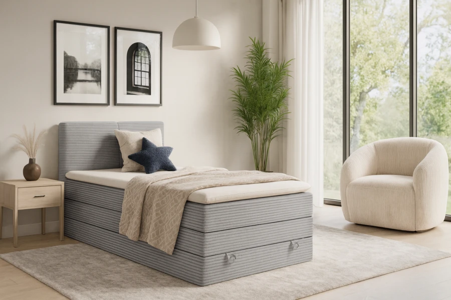 Stylish bedroom with light grey corduroy box spring bed and cosy armchair