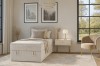 Modernes Schlafzimmer-Ambiente mit beige farbenem Cord-Einzelbett und stilvoller Einrichtung.